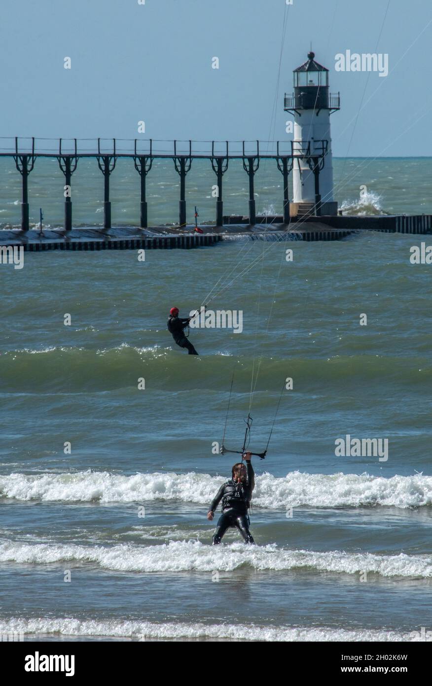 St Joseph MI USA, 26 settembre 2021; due kite surfisti tengono le linee strette per gli aquiloni mentre si godono le onde attive sul lago Michigan Foto Stock