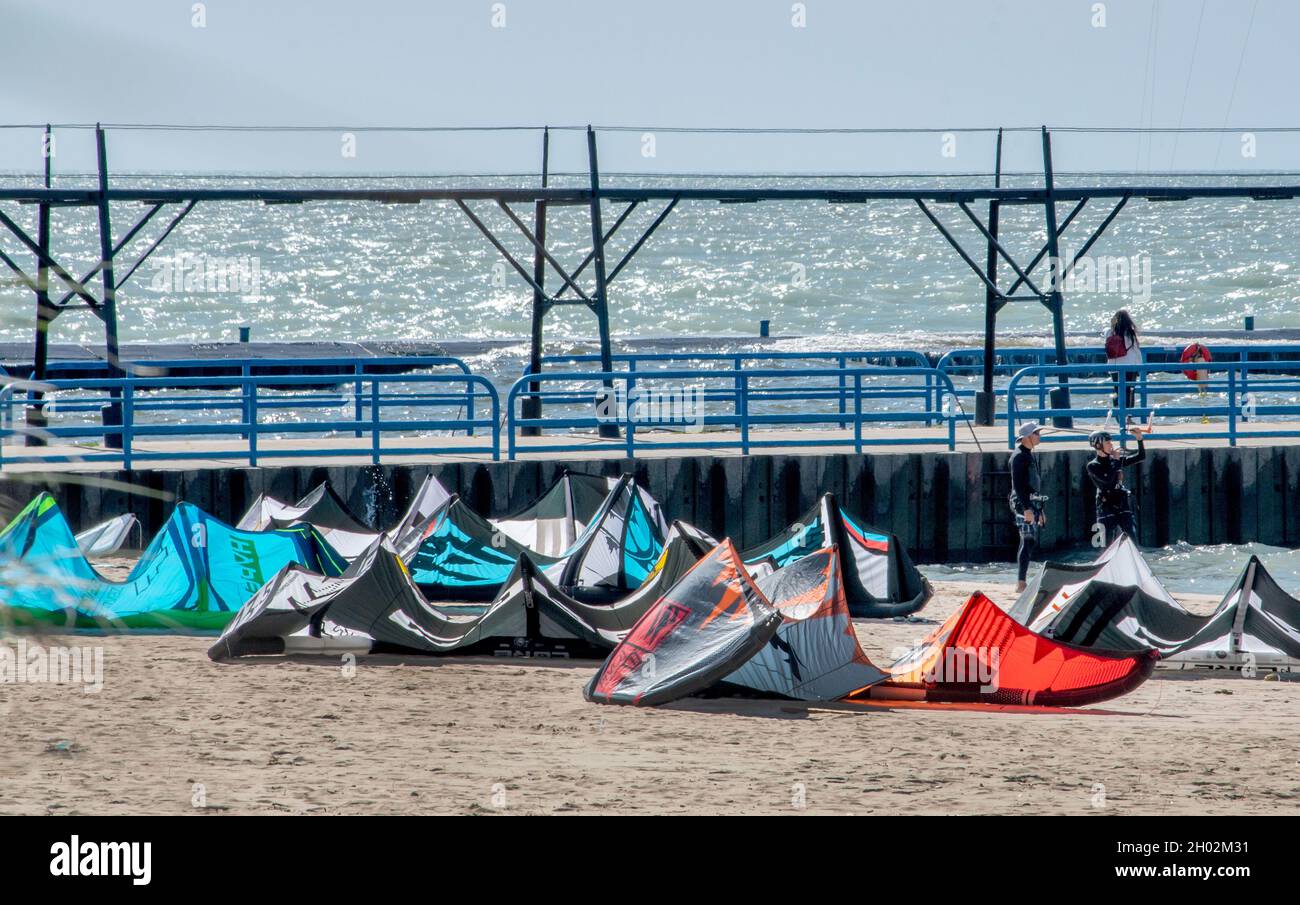St Joseph MI USA, 26 settembre 2021; un grande gruppo di kites surf si riposa sulla sabbia, mentre la gente aspetta che il vento prenda di nuovo sul lago Michigan Foto Stock