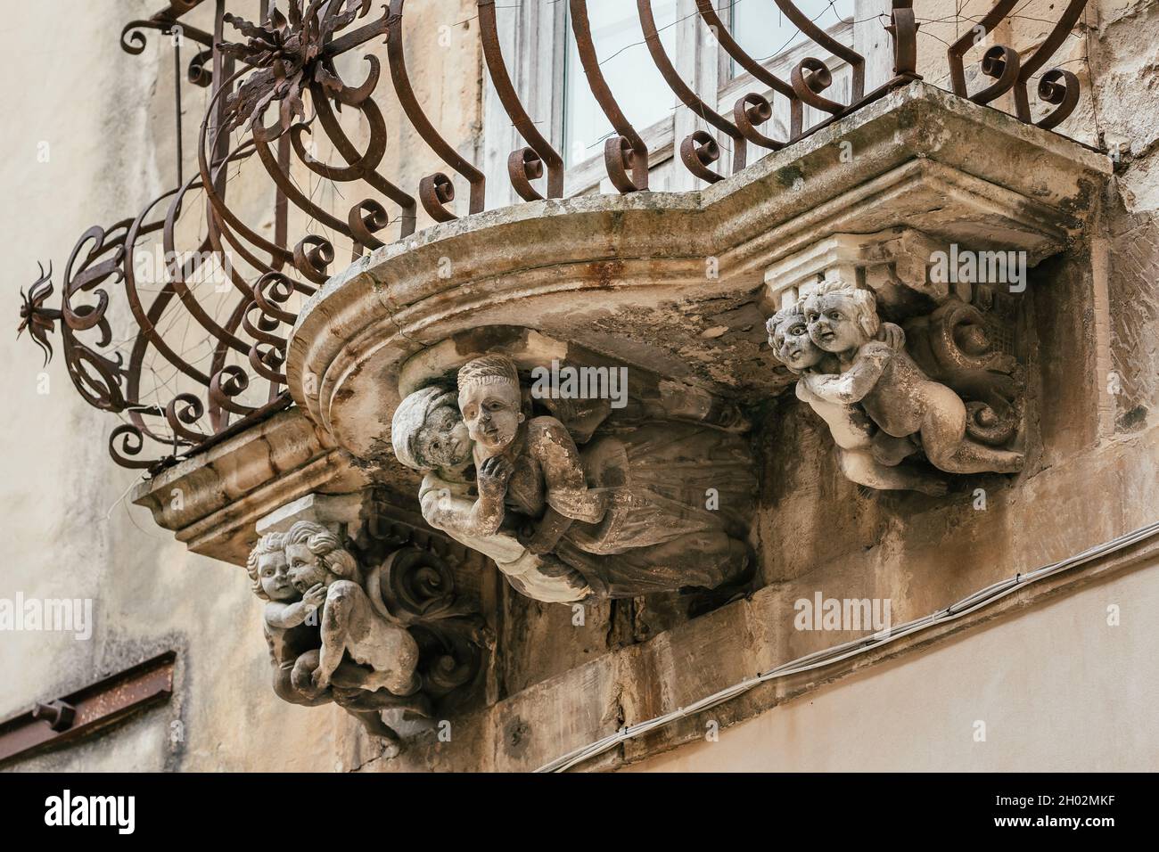 Bel mascaron barocco ornamento di un balcone nel centro storico di Ragusa, Sicilia Foto Stock