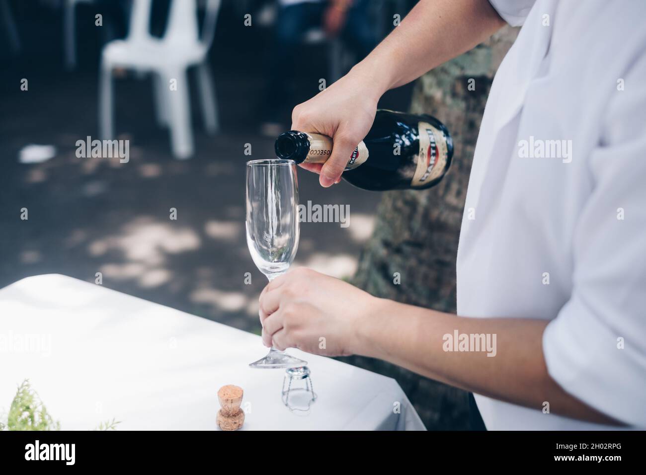 NORALA, PH– 22 SETTEMBRE 2021: Primo piano di mani versare la bottiglia di vino frizzante Martini in un alto vitigno. Messa a fuoco selettiva. Spazio di copia. Foto Stock