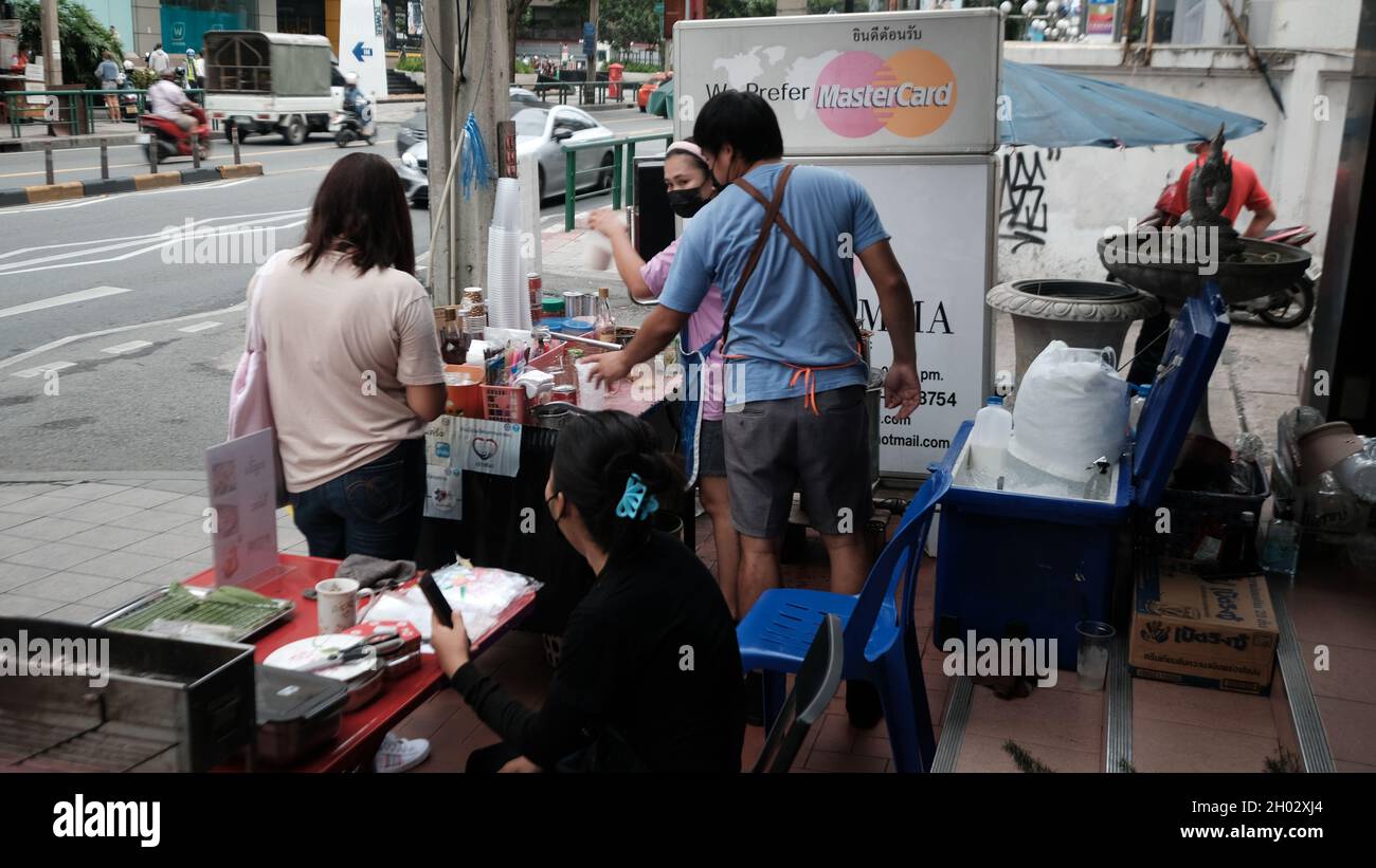 Money Changing Hands Buyer and Vender Street Food Asoke Road Sukhumvit Soi 21 Bangkok Thailandia Foto Stock