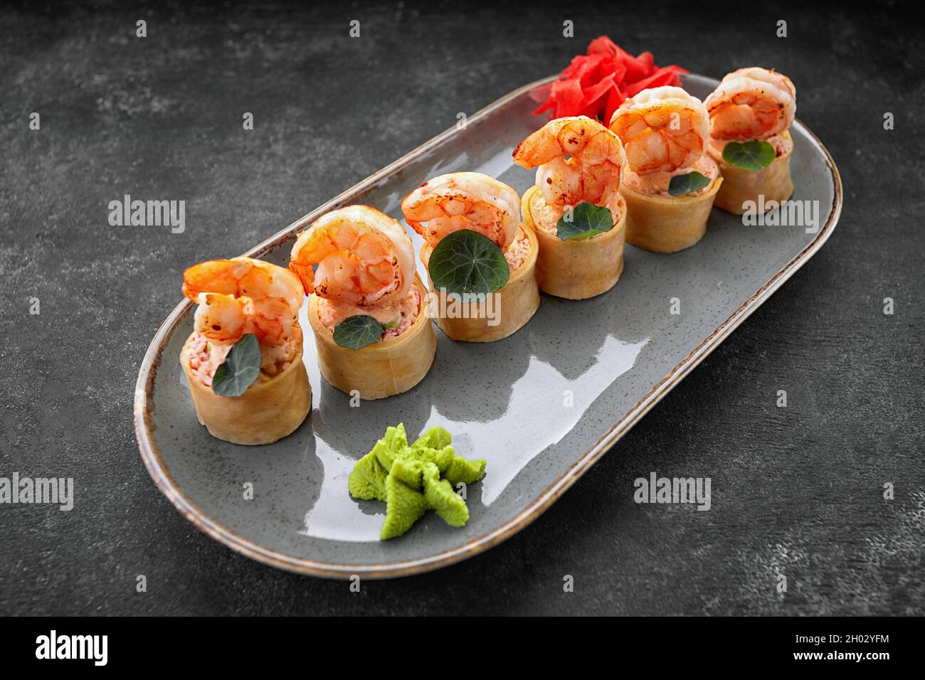 Sushi rotolini con omelette, gamberetti e bastoncini di granchio Foto Stock