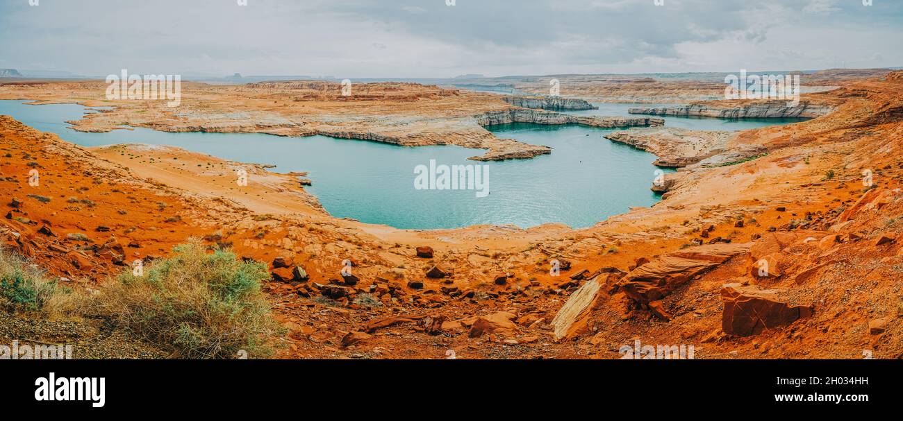 Vista sul lago Powell, panorama. Rocce rosse, scogliere, scogliere e cielo nuvoloso sullo sfondo, bella stagione autunnale Foto Stock