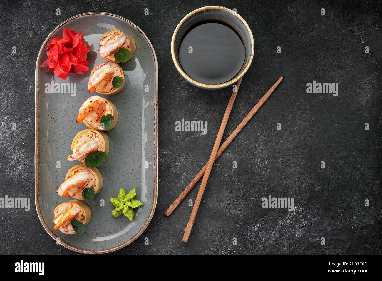Sushi rotolini con omelette, gamberetti e bastoncini di granchio Foto Stock