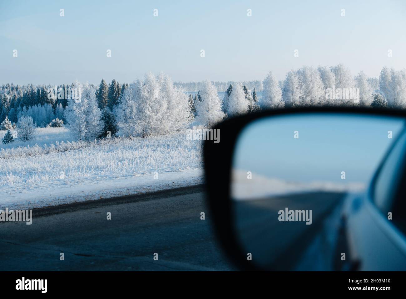 Paesaggio invernale mozzafiato sulla strada presa dalla macchina. Alberi ghiacciati e erba. Foto Stock