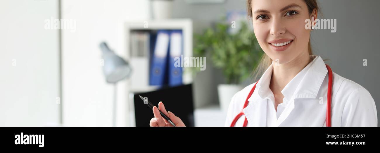 Ritratto di sorridente dottore con penna a sfera e stetoscopio sul collo Foto Stock