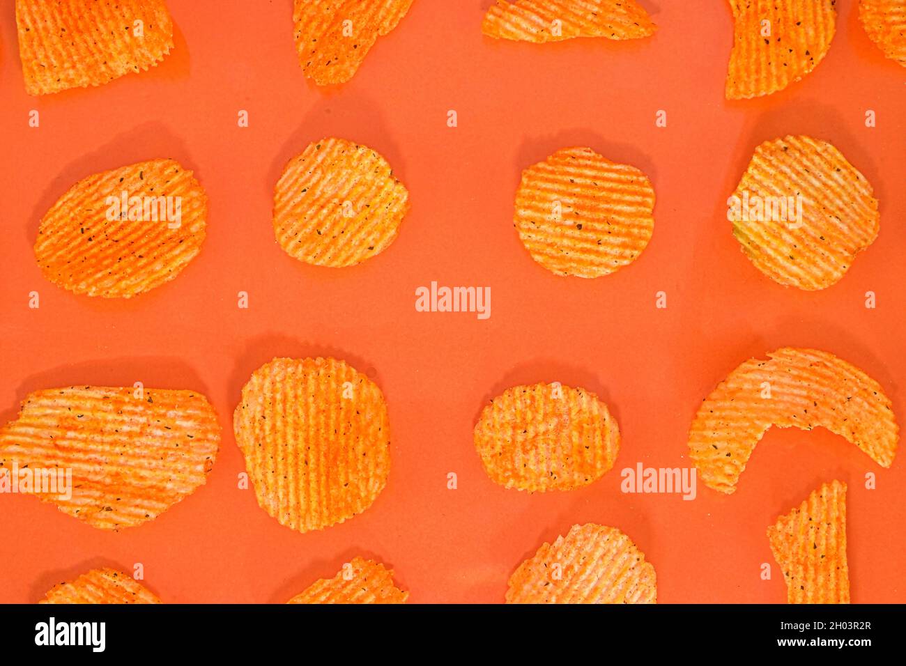 Raccolta di patatine fritte su sfondo arancione. Chili e patate. Cibo spazzatura. Primo piano. Disposizione piatta Foto Stock