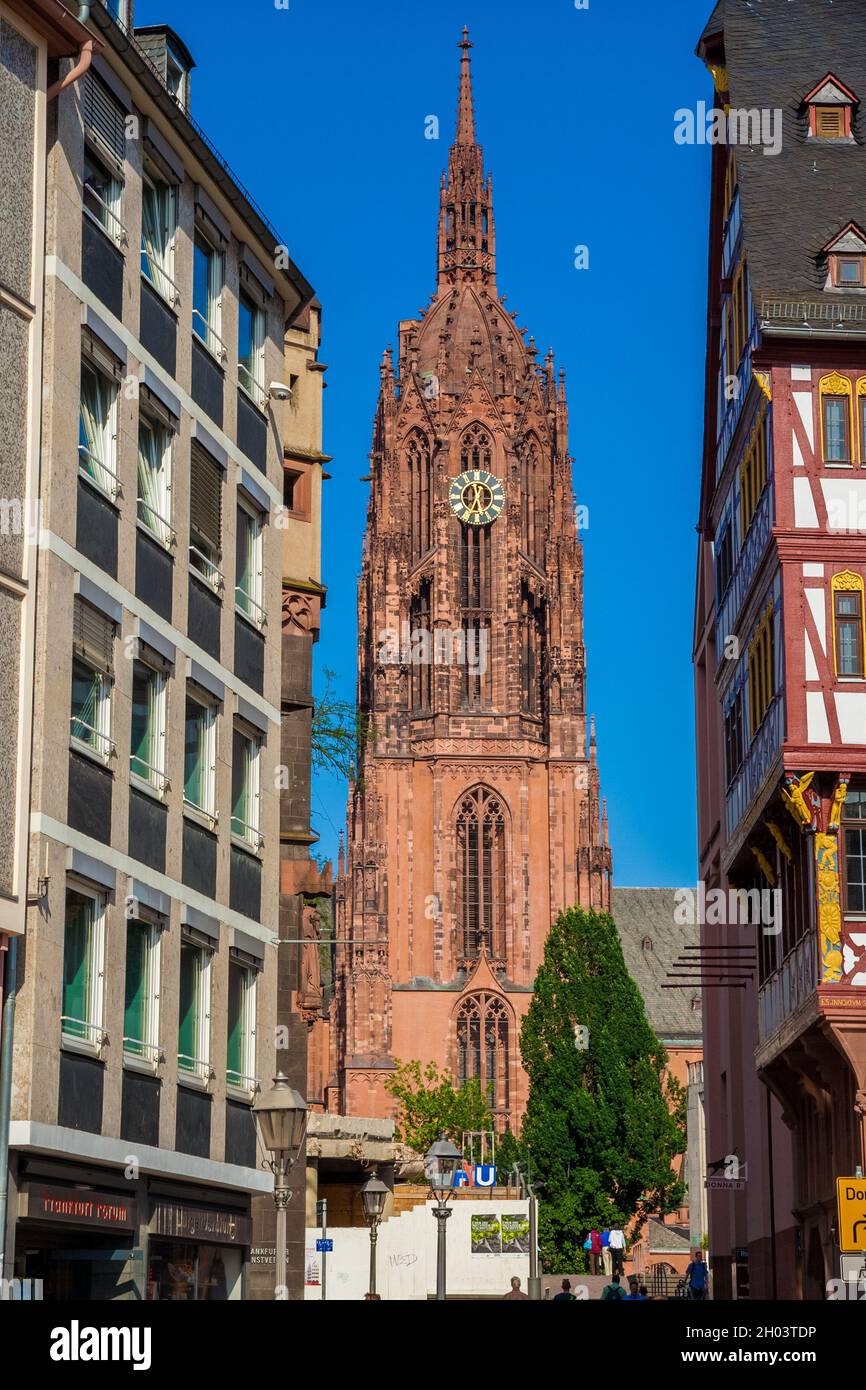 Splendida vista della torre della famosa cattedrale imperiale di San Bartolomeo tra gli edifici nella città vecchia di Francoforte, in Germania, su... Foto Stock