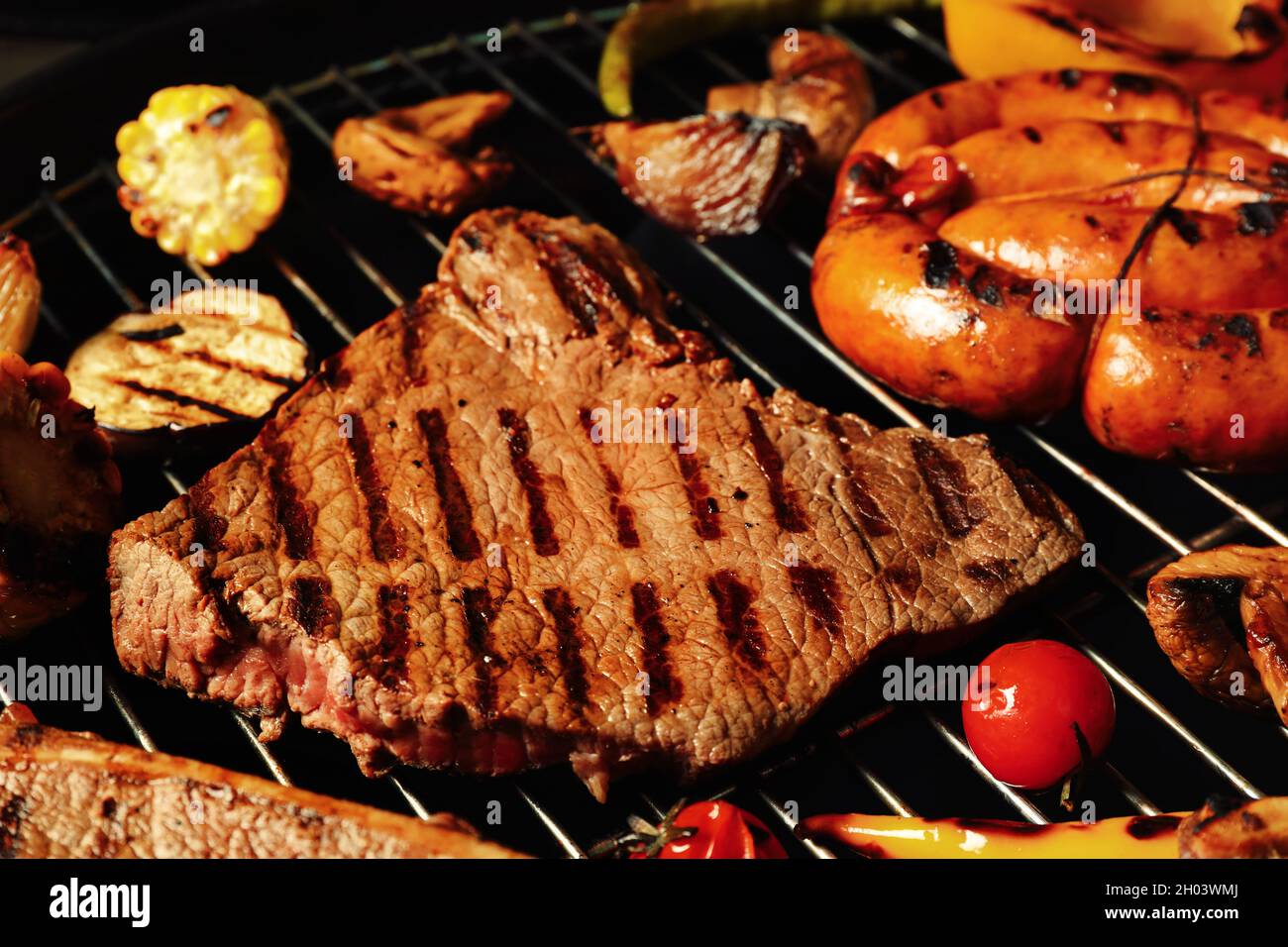 Bistecche di carne e verdure fresche alla griglia su grata al barbecue,  primo piano Foto stock - Alamy