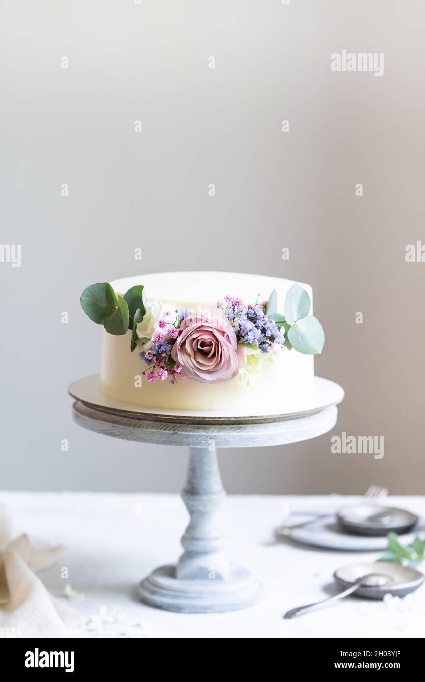 Torta fatta in casa con panna bianca e fiori Foto Stock