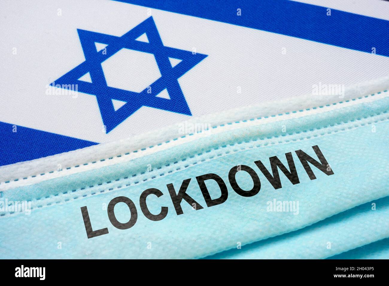 Bandiera d'Israele con maschera facciale e scritta con lucchetto. Foto Stock