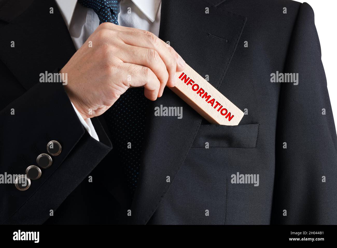 L'uomo d'affari toglie un blocco di legno dalla sua tasca con la parola informazioni. Concetto di gestione delle informazioni aziendali Foto Stock