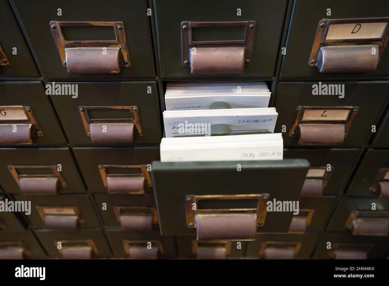 Aprire il cassetto dei file di archivio su un vecchio armadio di archiviazione in metallo Foto Stock