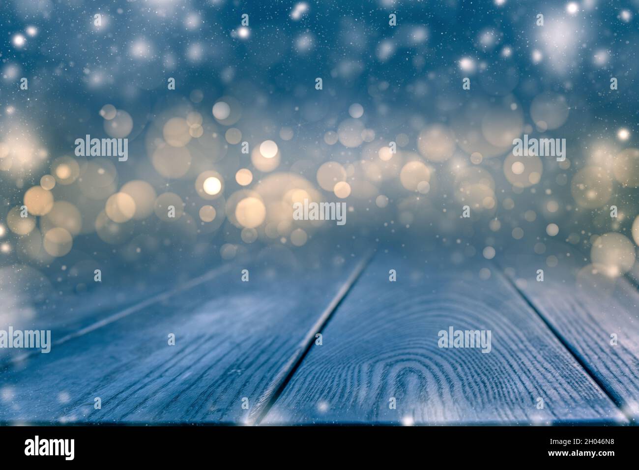 Vista panoramica notturna invernale con luci bokeh. Pannello in legno ricoperto di neve con spazio per copiare le idee dello yoir. Foto Stock