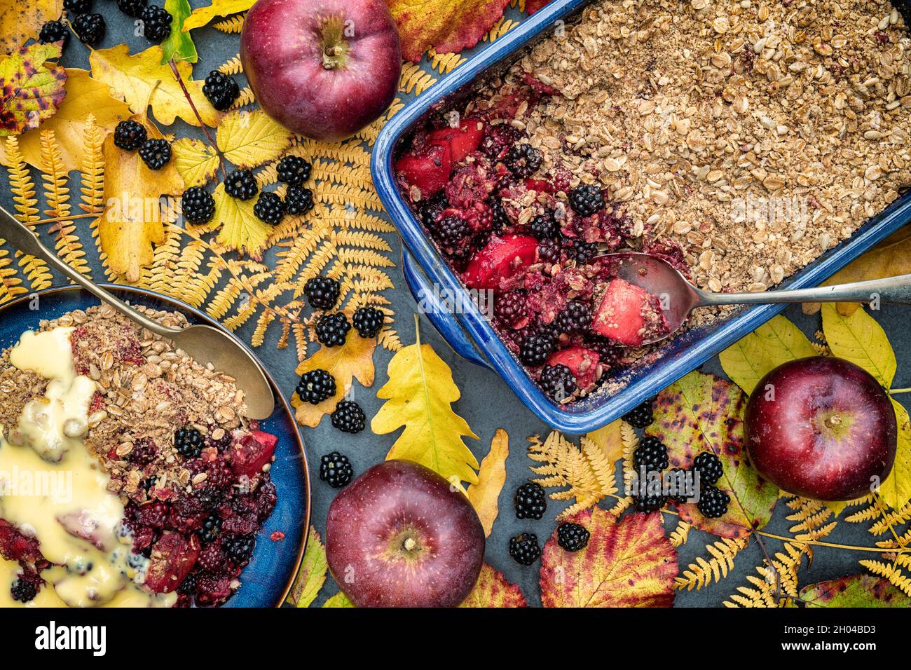 Mora e crumble di mela fatti in casa e crema pasticcera. OAT biologico e semi sbriciolati con more e mele rosse preinvecchiate Foto Stock
