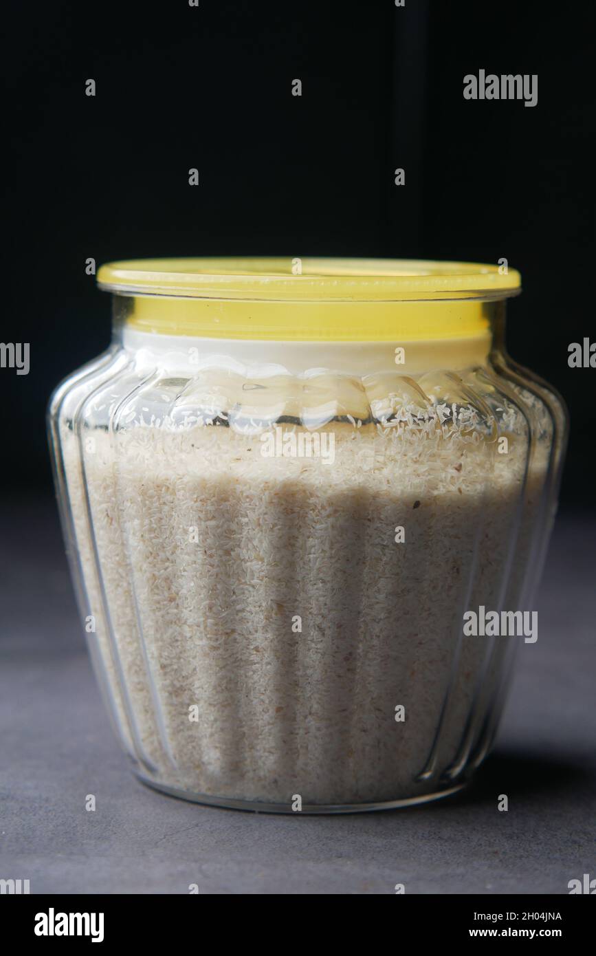 Psyllium Seeds 0n un contenitore su sfondo scuro Foto Stock