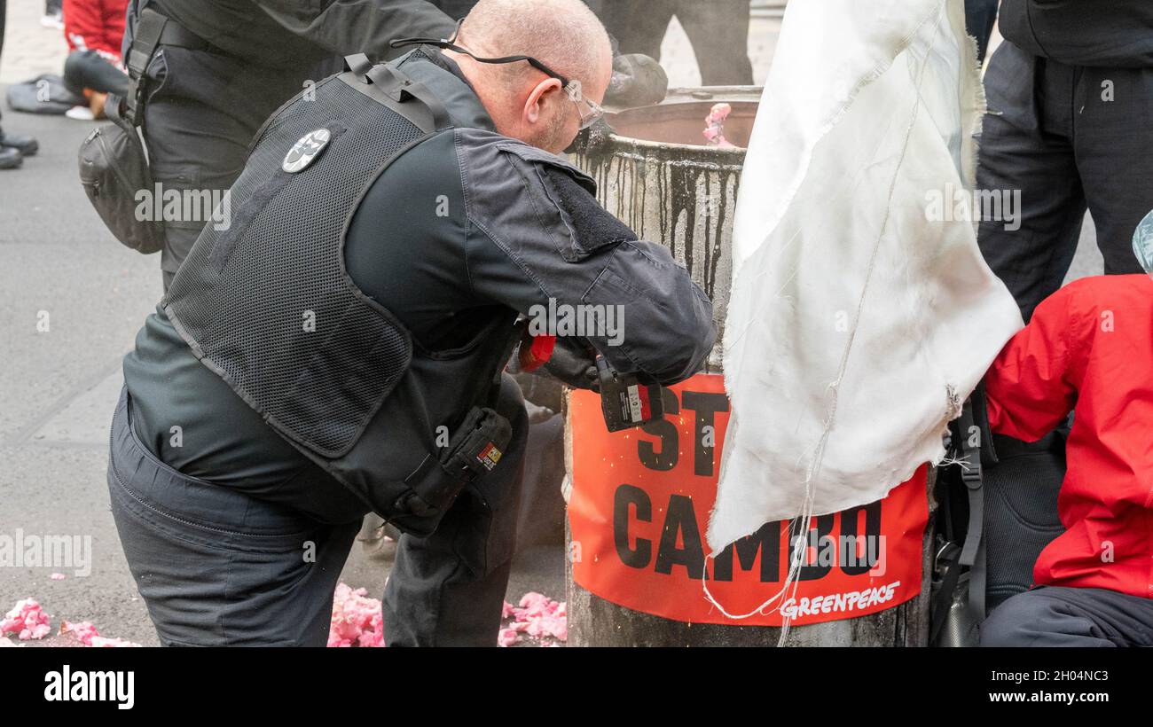 Londra, Regno Unito. 11 ottobre 2021. Gli attivisti di Greenpeace bloccano Whitehall al di fuori di Downing Street Londra sul campo petrolifero di cambo e vengono rimossi dalla polizia e dalla squadra di rimozione delle proteste Credit: Ian Davidson/Alamy Live News Foto Stock