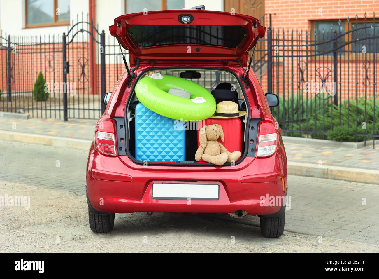 Valigie, giocattoli e cappello nel bagagliaio della strada della città Foto  stock - Alamy