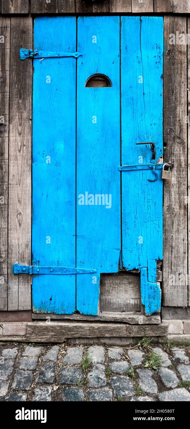 Vecchio chiuso a chiave, porta in legno blu turchese in tre vecchie travi con un lucchetto, brillante impressione Foto Stock