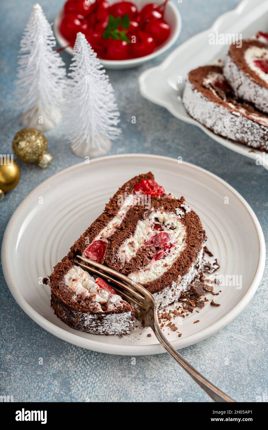 Rotolo di torta della foresta nera con panna montata e ciliegie, dessert per Natale Foto Stock