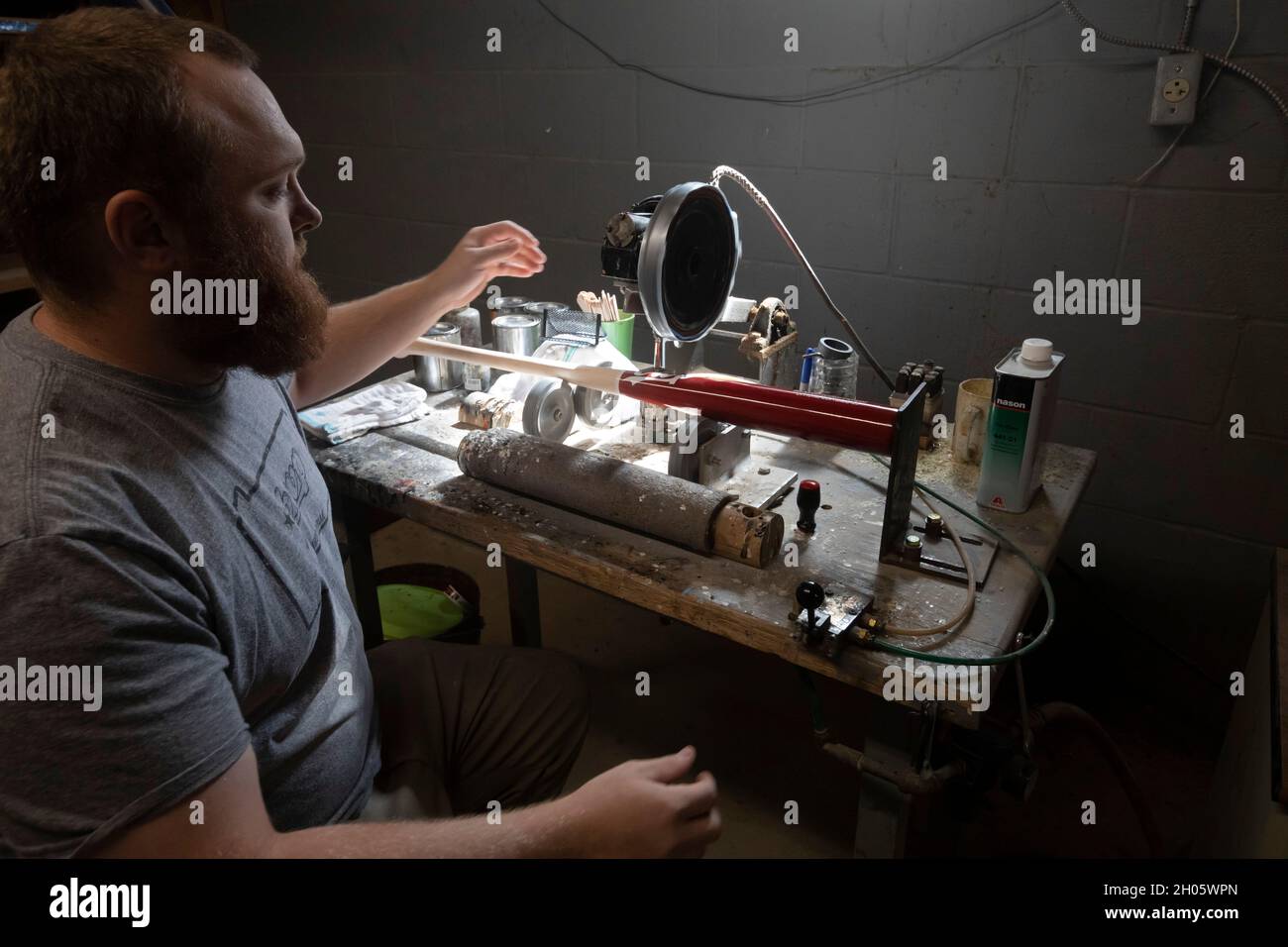 Brookville, Pennsylvania - i pipistrelli da baseball sono prodotti a BWP Bats. Kevin Gnacinski dipinge una linea di transizione per separare i due colori sul pipistrello. Foto Stock