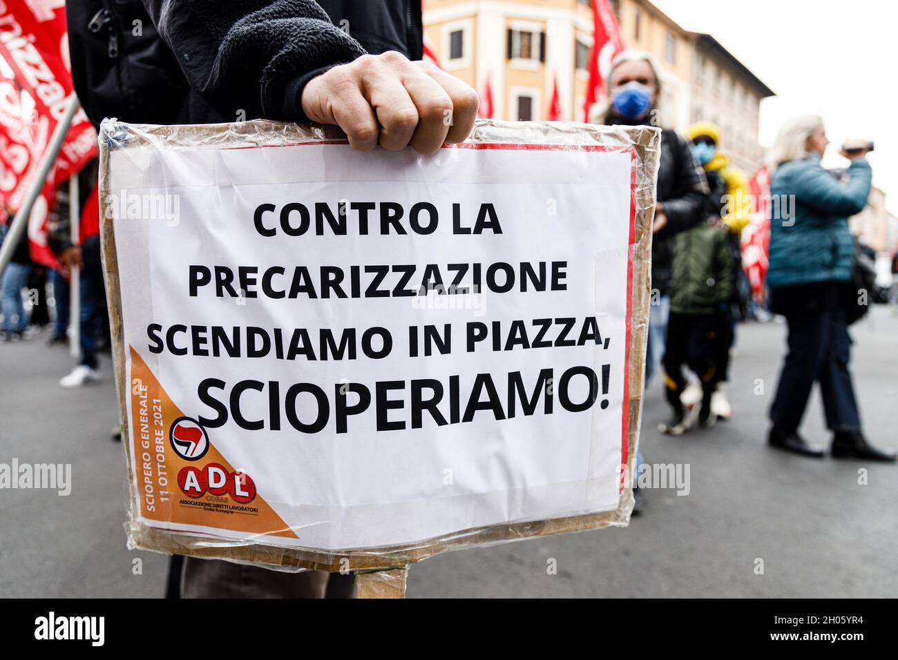 Bologna, Italia. 11 ottobre 2021. I manifestanti hanno una bandiera durante uno sciopero generale chiamato dai sindacati popolari (Cobas, Cub, USB) contro il governo Draghi. Alla protesta hanno partecipato circa 3000 persone, tra studenti e lavoratori, sfilando per le strade del quartiere di Bolognina e del centro storico. Credit: Massimiliano Donati/Alamy Live News Foto Stock