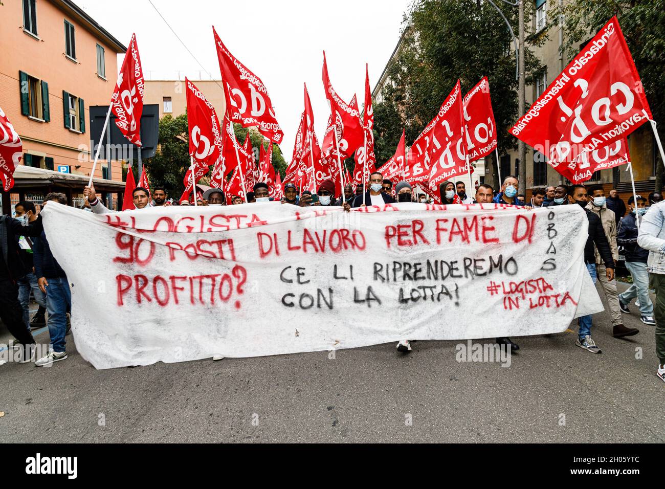 Bologna, Italia. 11 ottobre 2021. I manifestanti hanno una bandiera durante uno sciopero generale chiamato dai sindacati popolari (Cobas, Cub, USB) contro il governo Draghi. Alla protesta hanno partecipato circa 3000 persone, tra studenti e lavoratori, sfilando per le strade del quartiere di Bolognina e del centro storico. Credit: Massimiliano Donati/Alamy Live News Foto Stock