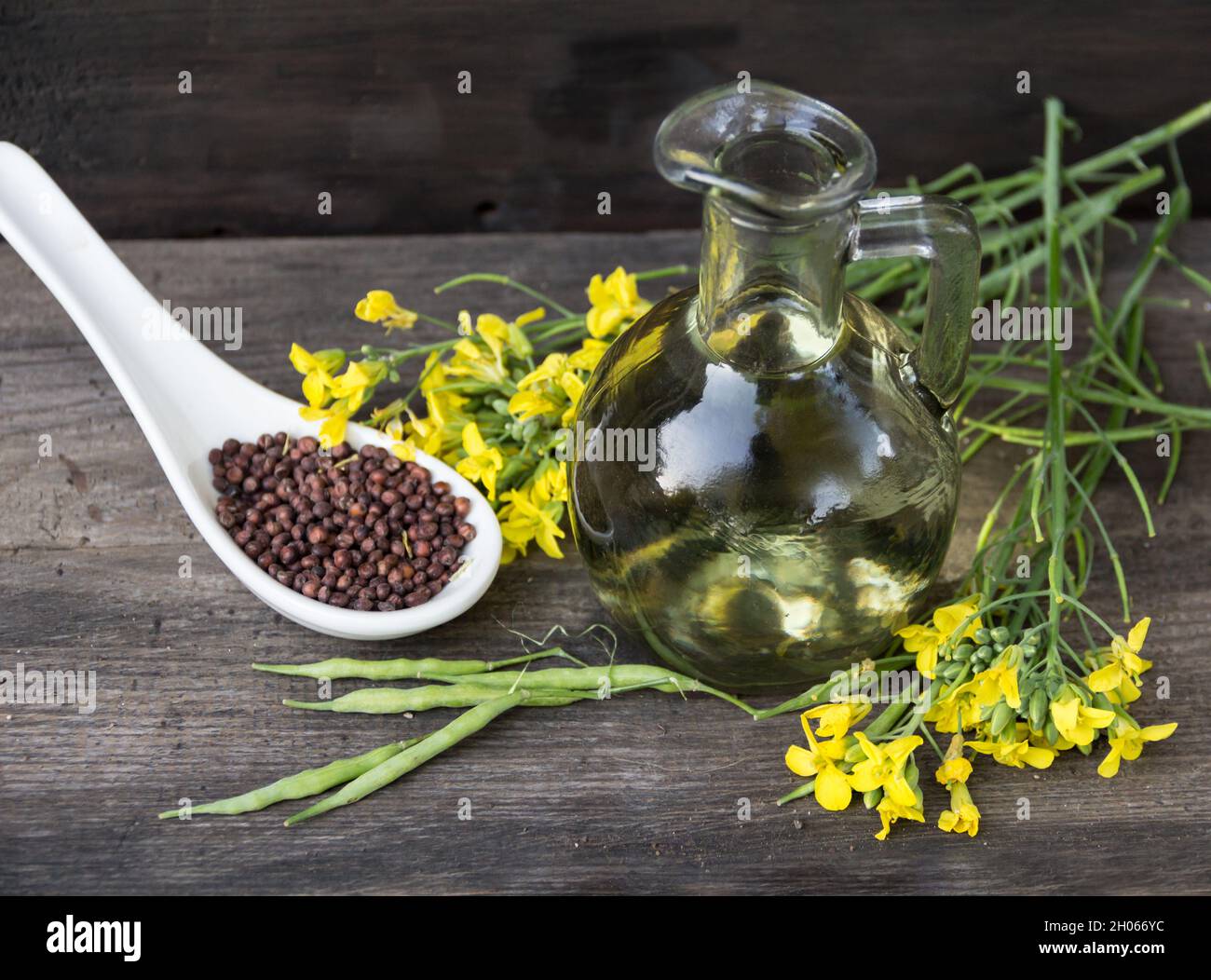 olio di canola, fiori e semi su legno rustico Foto stock - Alamy