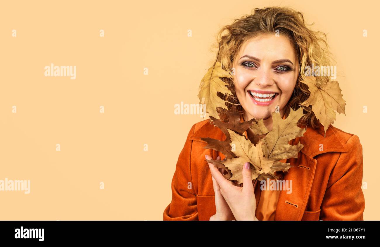 Perfetto modello di moda donna con foglie autunnali. Ragazza alla moda in giacca arancione. Bellezza autunnale. Spazio di copia Foto Stock