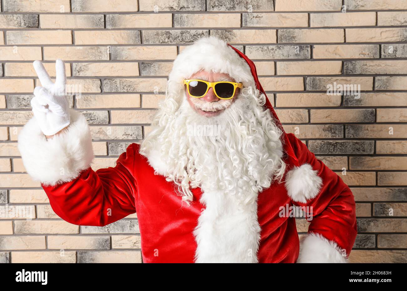 Autentico Babbo Natale indossare occhiali da sole su sfondo muro di mattoni  Foto stock - Alamy