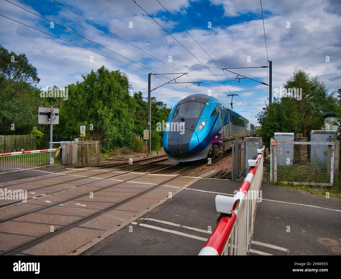 Un treno Transpennine Express che viaggia ad alta velocità a Northumberland, Regno Unito - preso in una giornata di sole con le nuvole bianche. Foto Stock