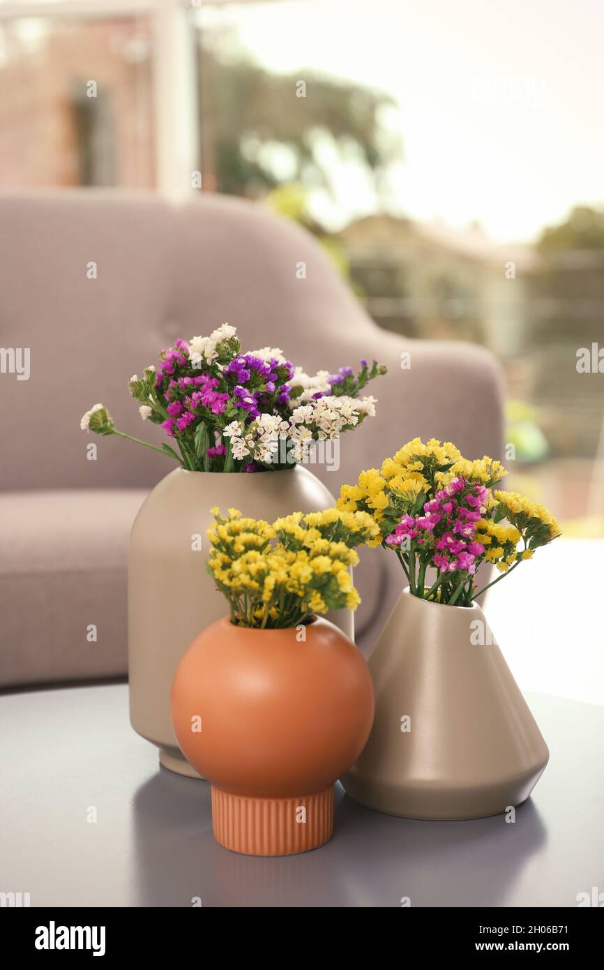 Bellissimi fiori in vasi sul tavolo. Elemento di interior design Foto stock  - Alamy