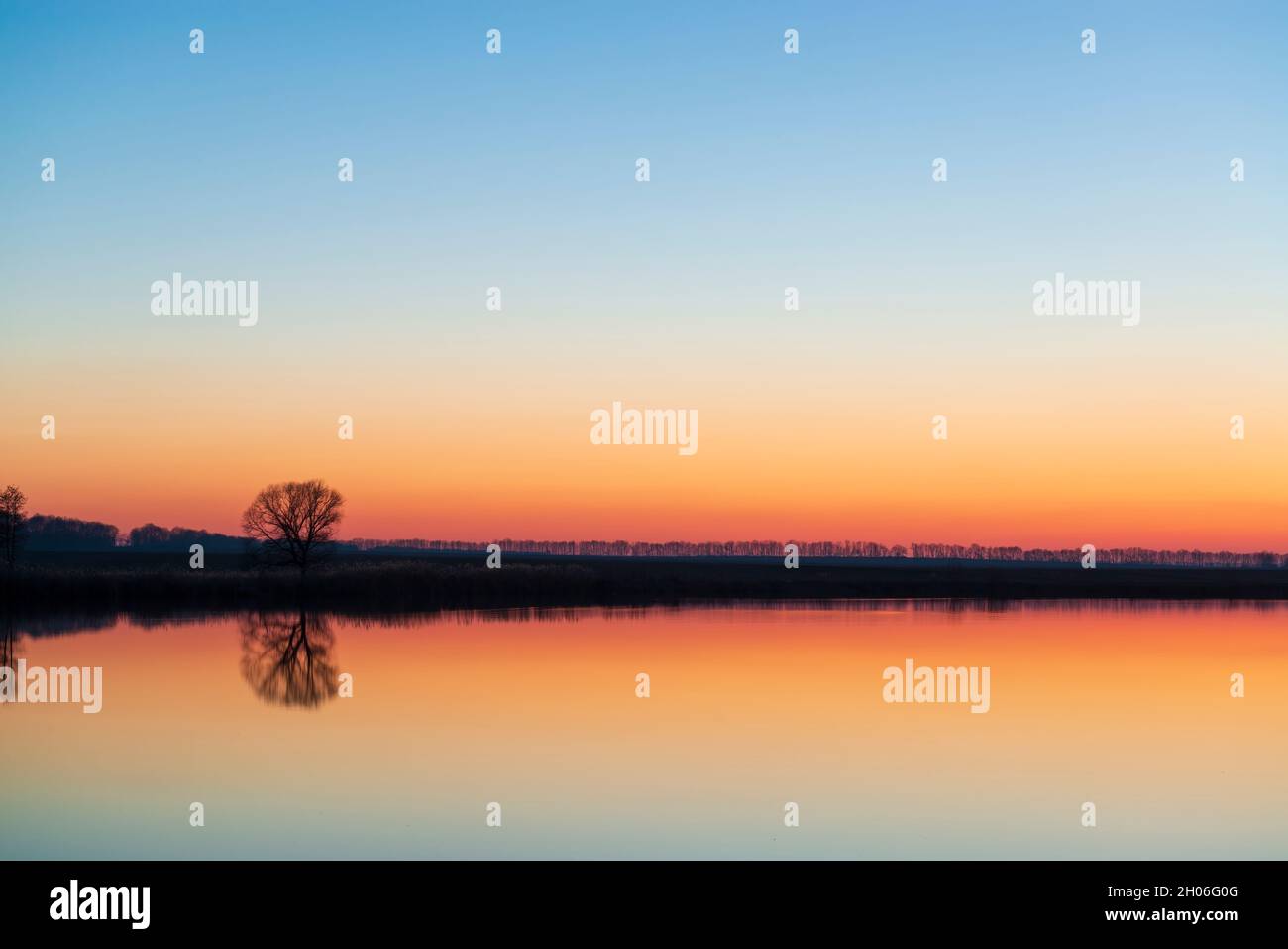 Tramonto tranquillo sul lago. Lago tranquillo specchio Foto Stock