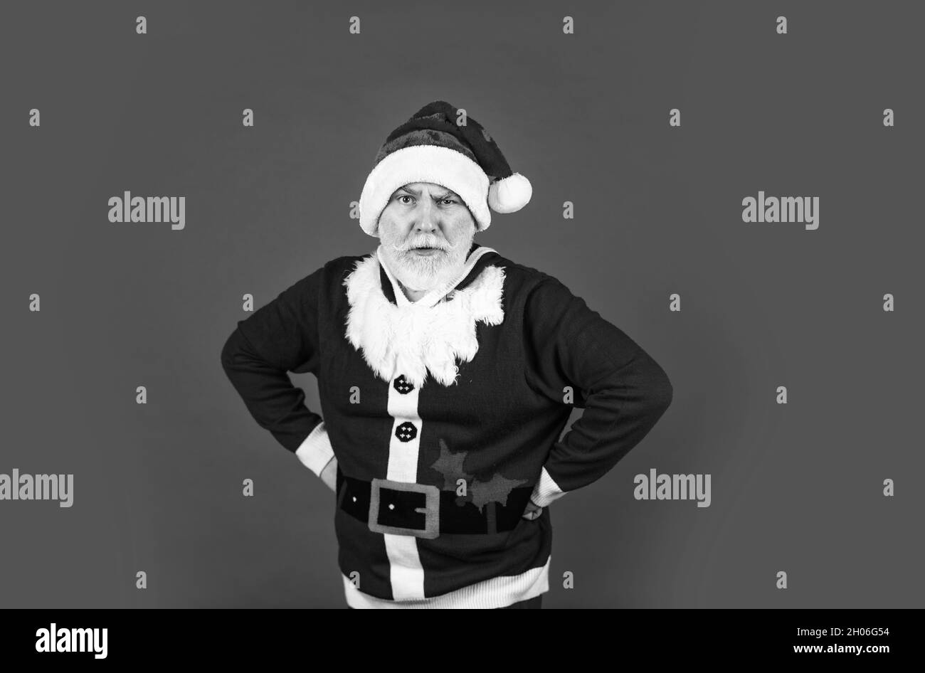 Vacanza migliore. buon natale. ha sopportato santa in cappello su sfondo rosso. Regali di Natale e tempo di shopping del regalo. Gioia di festa di inverno. Uomo anziano serio dentro Foto Stock