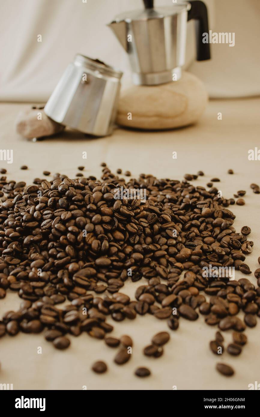 Set di chicchi di caffè in una caffettiera di fondo su sfondo marrone. Fotografia del caffè di Still Life. Foto Stock