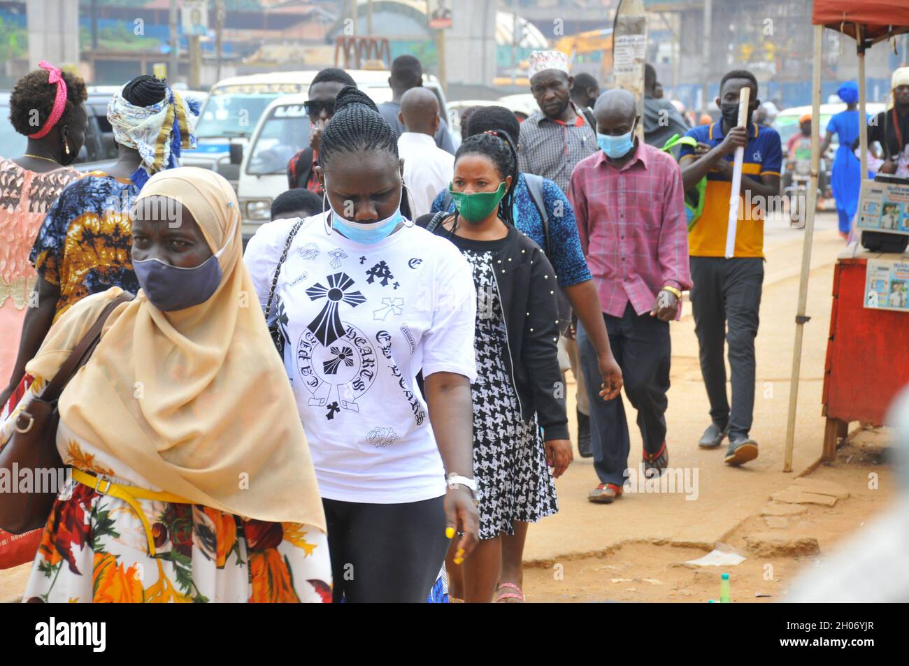 Persone che indossano maschere. La direttiva del governo prevede che le persone indossino una maschera per combattere la pandemia del Covid – 19. L'economia di tutti gli stati è stata colpita duramente e i bambini delle classi inferiori non hanno frequentato la scuola da molto tempo. Kampala City, Uganda. Foto Stock