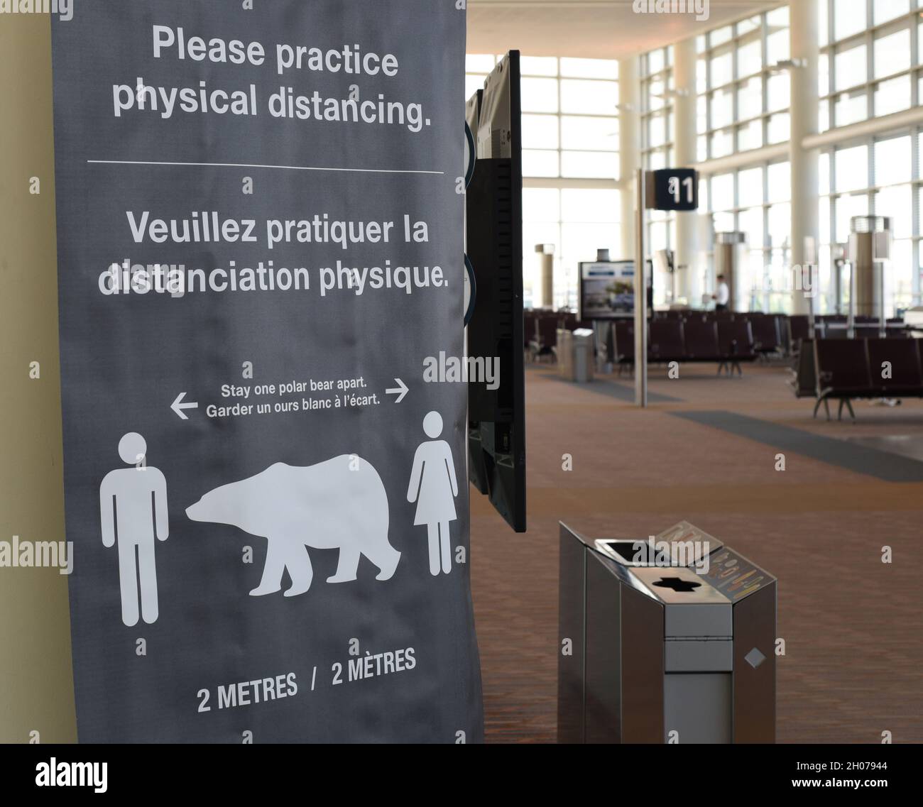 Un cartello presso l'aeroporto internazionale di Winnipeg utilizza un simbolo di orso polare come la distanza per praticare la distanza fisica per la sicurezza di Covid-19 a Winn Foto Stock