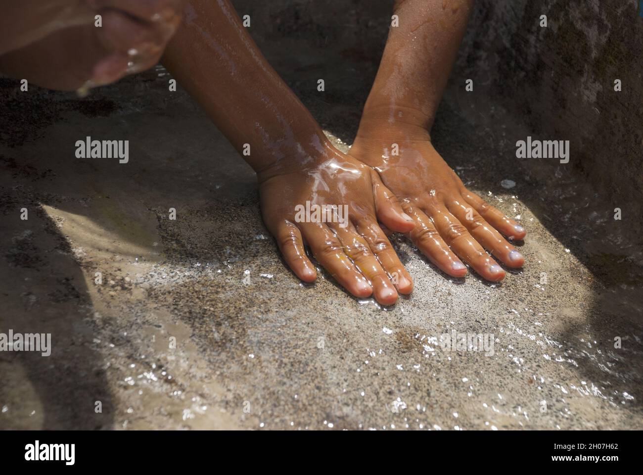 Mani dei bambini latini che dipingono e bevono acqua, celebrazione educativa. Foto Stock