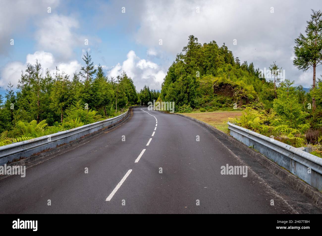 Strada asfaltata vuota con vegetazione verde a Lagoa do Fogo (Lago dei Vigili del fuoco) a São Miguel, Azzorre - Portogallo Foto Stock