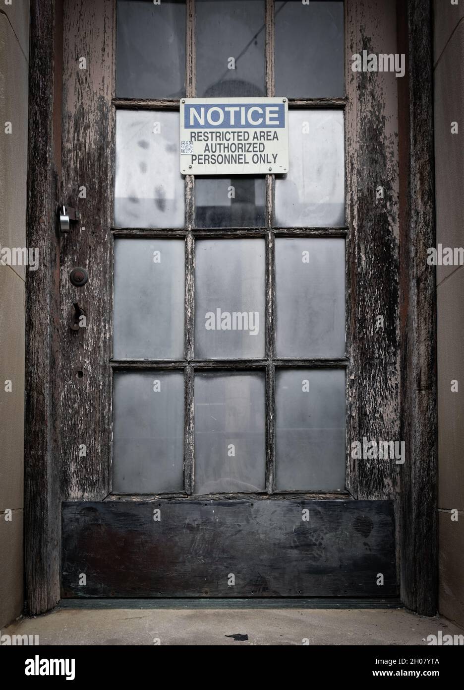 Porta rustica con intemperie con serratura e cartello di accesso limitato Foto Stock
