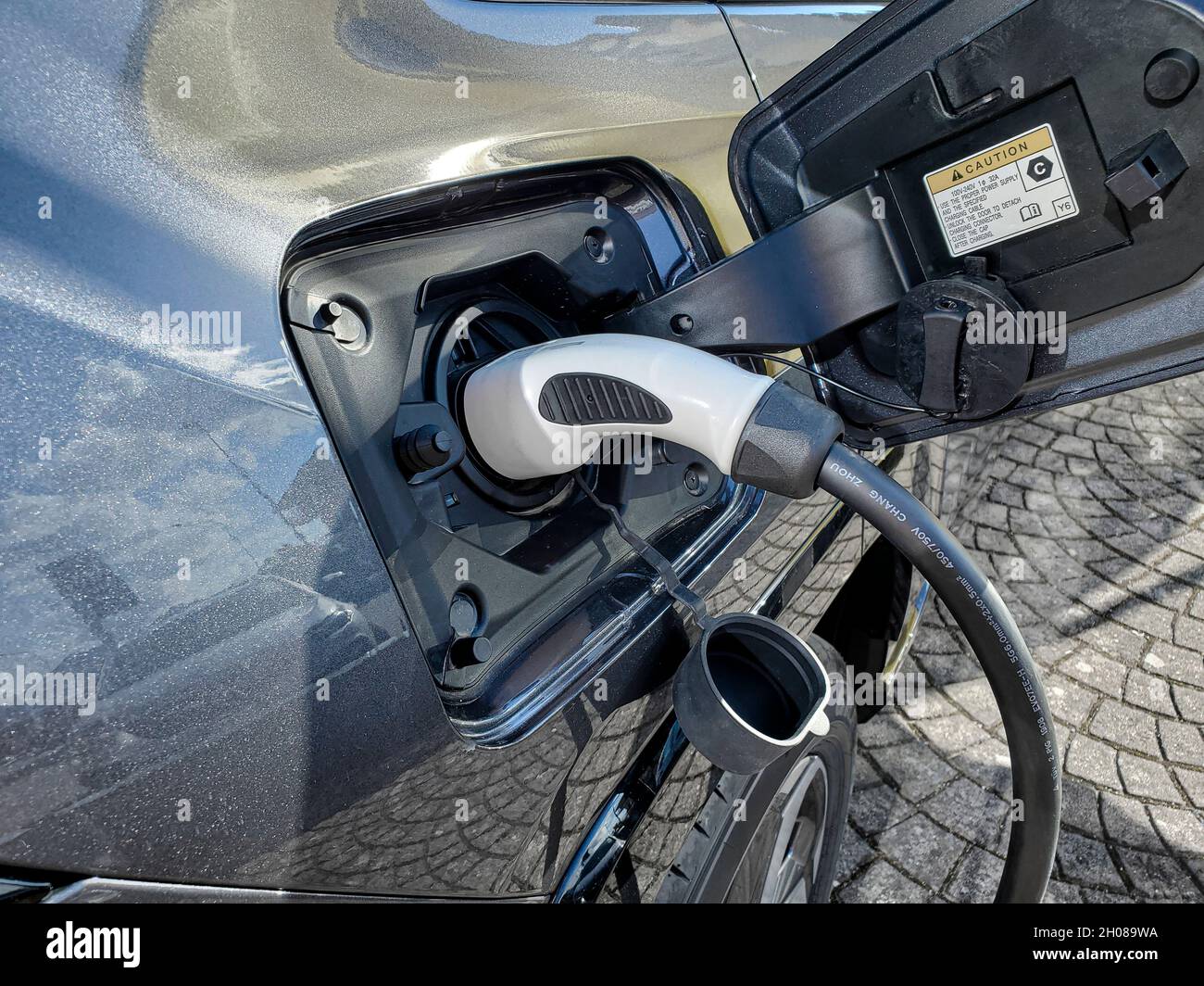 Auto elettrica mentre si ricarica la batteria alla centrale elettrica,nuova tecnologia automobilistica Foto Stock