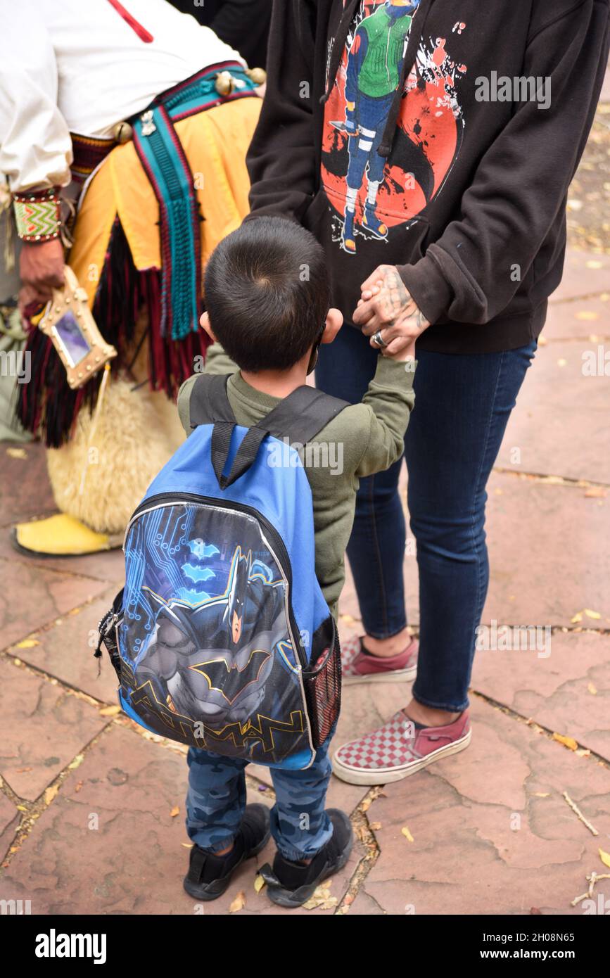 Una donna dei nativi americani e il suo giovane figlio tengono le mani in attesa dell'inizio della celebrazione della Giornata dei popoli indigeni a Santa Fe, New Mexico. Foto Stock