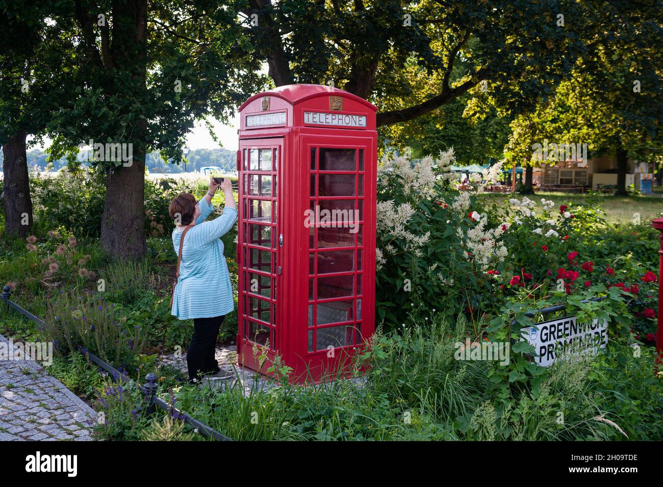 '13.06.2019, Germania, , Berlino - Una donna scatta una foto di un tipico stand telefonico britannico rosso scartato (modello K6) in un parco lungo il Greenwich Foto Stock