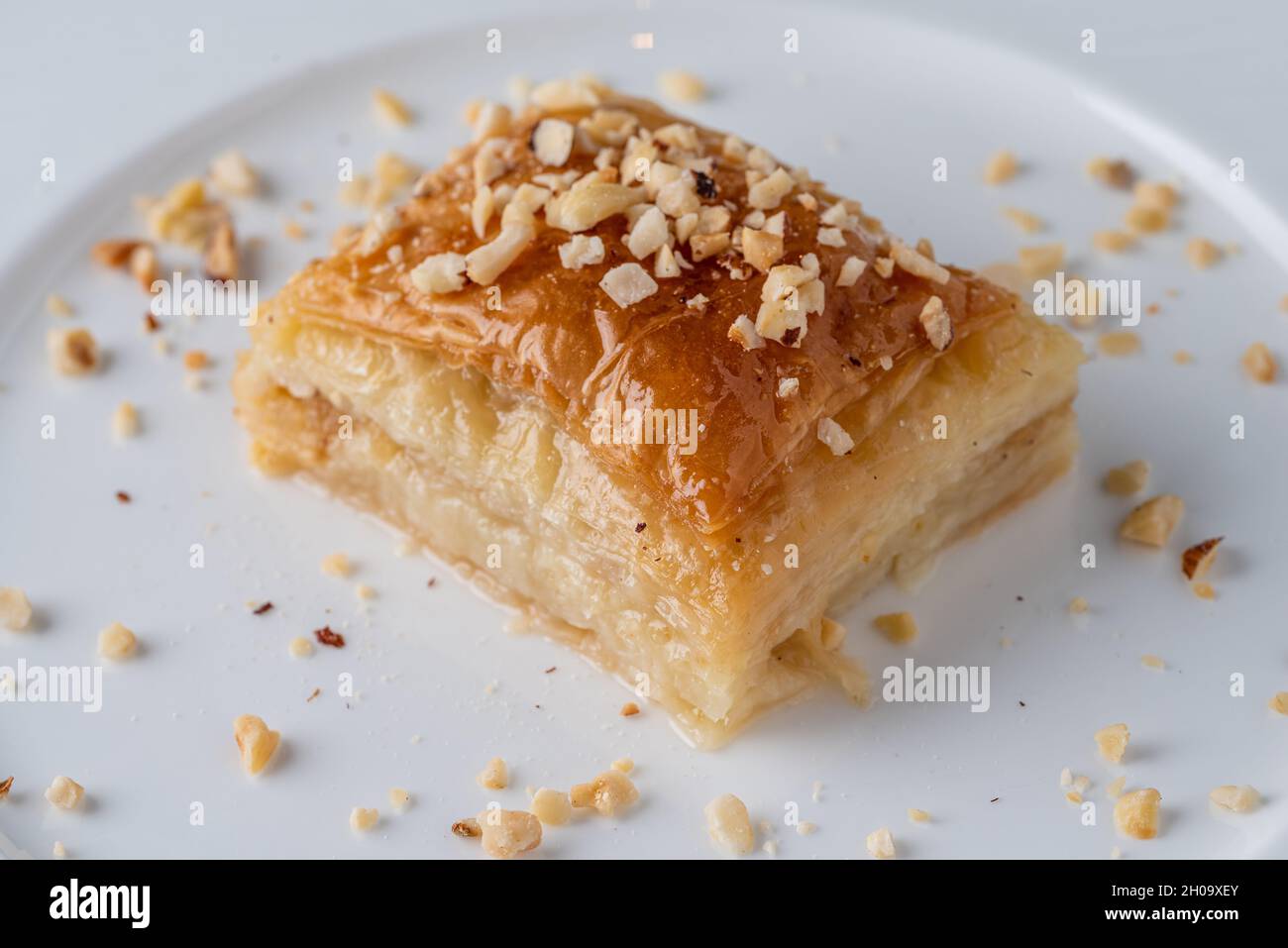 Baklava turca con nocciole su un piatto di porcellana bianca Foto Stock