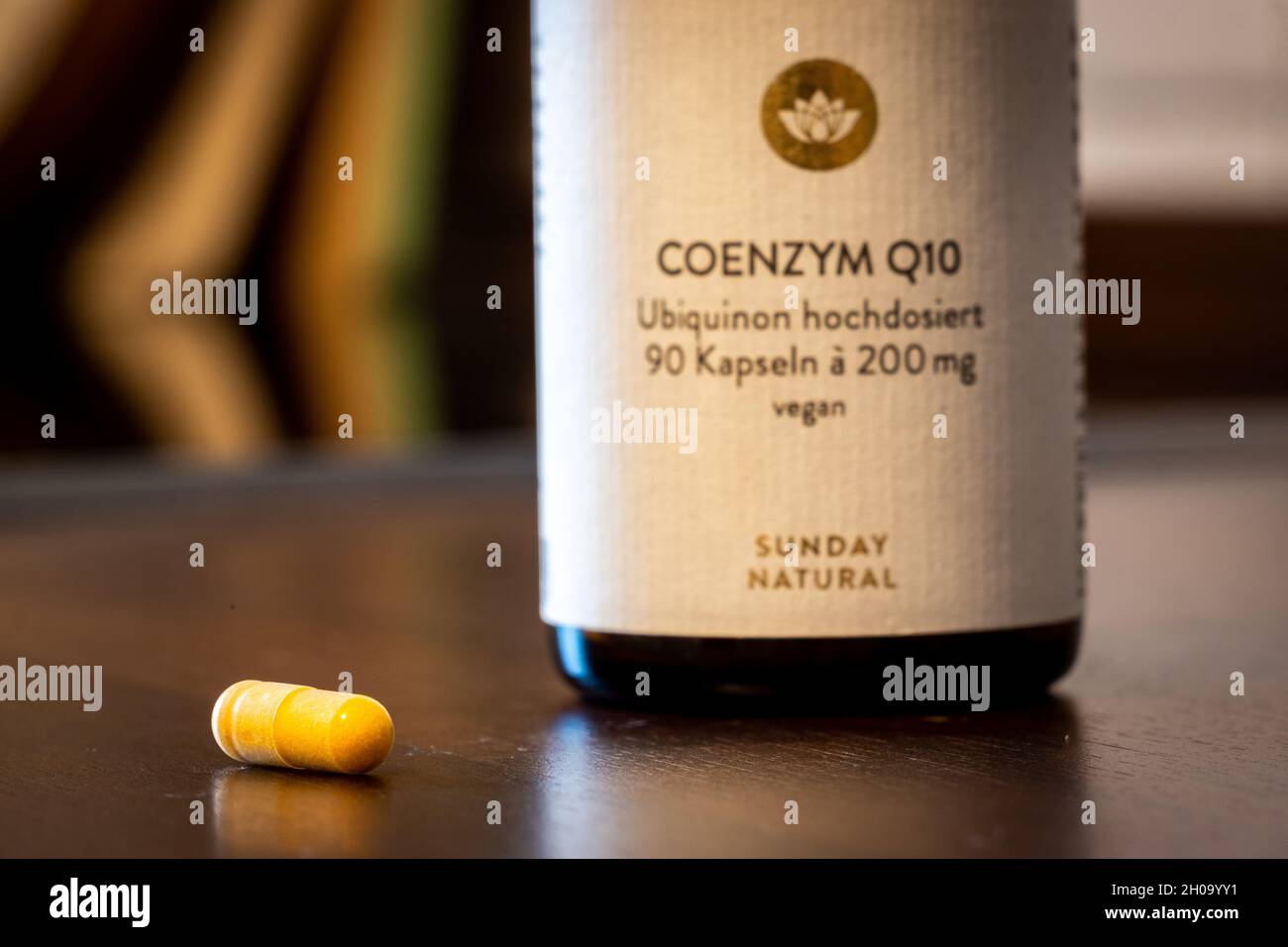 Una pillola di Q10 e il suo flacone Foto Stock
