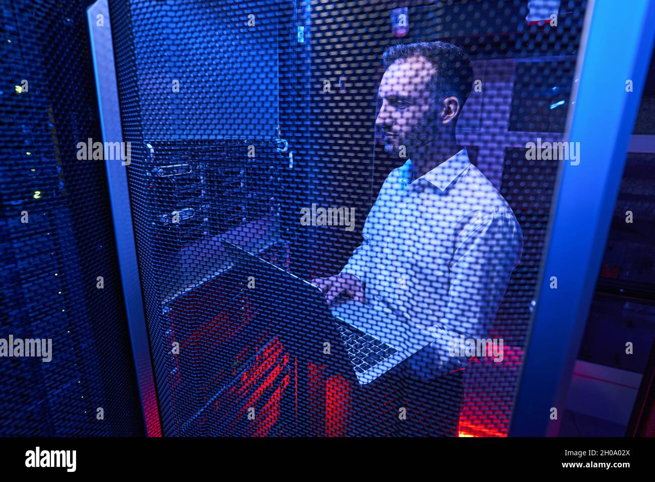 Amministratore di sistema professionale che mantiene la sicurezza dei dati nel centro di co-locazione Foto Stock