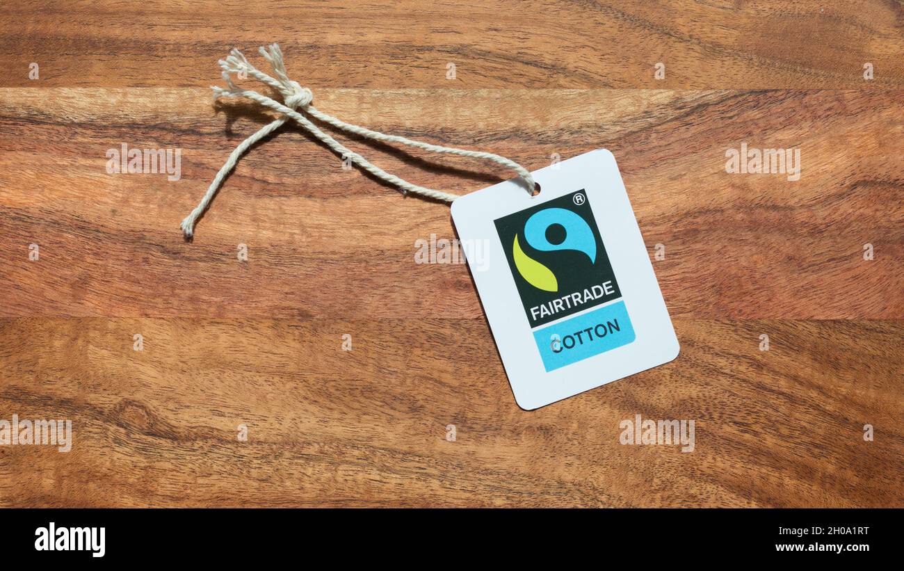 Gauting, Germania - Apr 20, 2021: Etichetta Fairtrade Cotton su sfondo di legno. Foto Stock