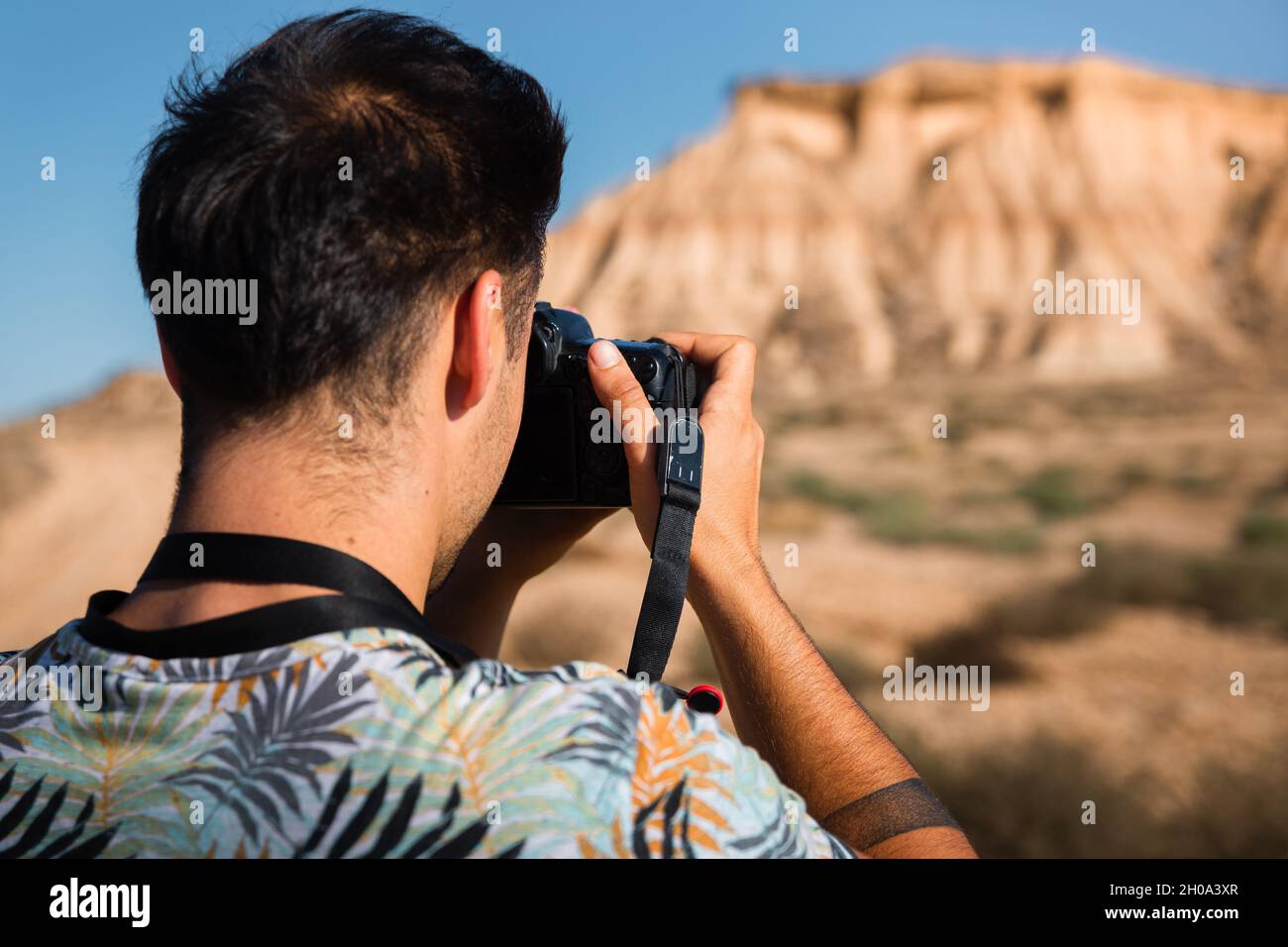 Giovane uomo con una macchina fotografica nel deserto di Bardenas Reales, Navarra, Paesi Baschi. Foto Stock