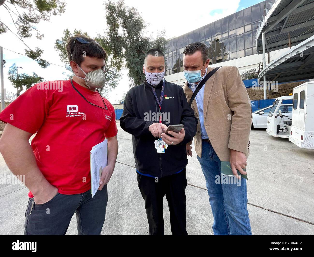 Chad D. Allen, a sinistra, ingegnere residente con l'Edwards Air Force base Resident Office del corpo dell'esercito degli Stati Uniti di ingegneri Los Angeles District, si unisce Justin Gay, a destra, un program manager anche con IL LA District, per rivedere i dati pertinenti con Ryan Berry, direttore dell'assistenza sanitaria per Howe Bonney & Associates, durante una valutazione del sito presso il Providence Holy Cross Medical Center di Mission Hills, California, 5 gennaio 2021. Il Distretto di Los Angeles, il corpo degli ingegneri dell'esercito degli Stati Uniti, in coordinamento con e a sostegno dell'Ufficio dei servizi di emergenza del Governatore della California e del Mana federale di emergenza Foto Stock