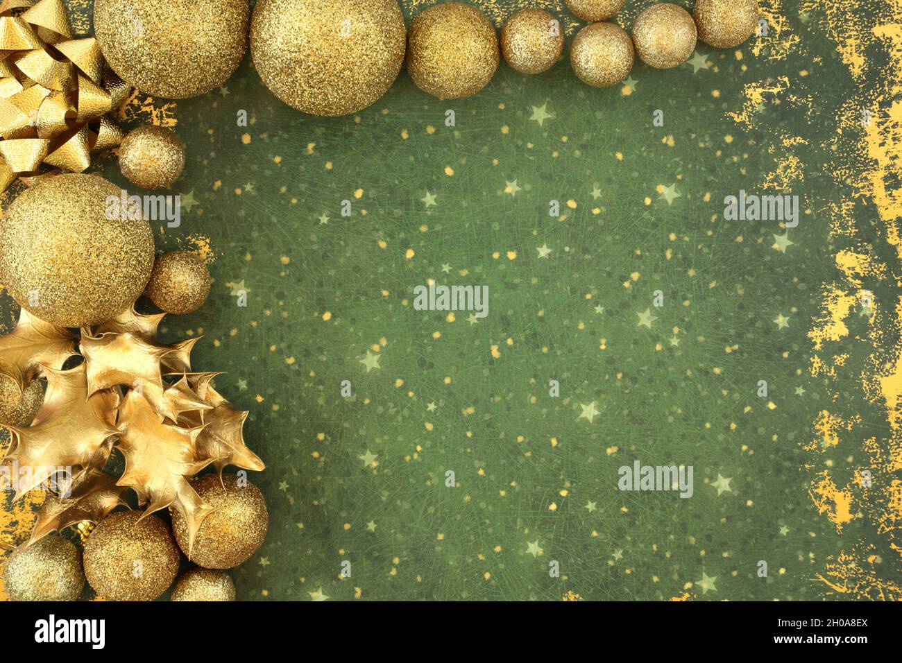 Astratto sfondo natalizio bordo con scintillante oro glitter bauble albero decorazioni, foglie di agrifoglio. Composizione festiva per la stagione delle feste. Foto Stock